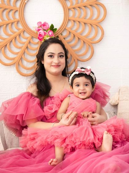 Mother and daughter in matching pink dresses. This is a beautiful way to create a memorable and adorable portrait that highlights their special bond.