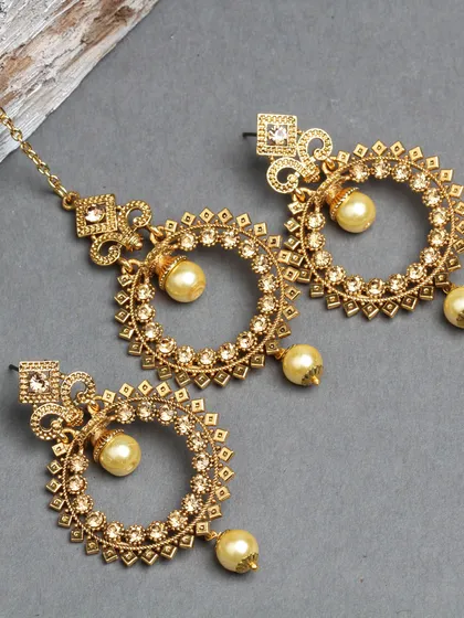 A gold-plated hoop earring and maang tika set with pearl drops.