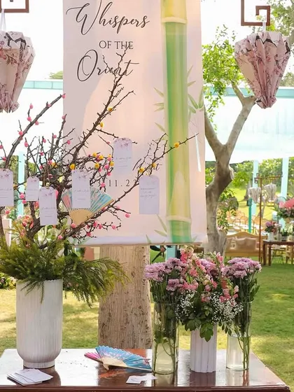 The guest seating chart for 'Whispers of the Orient', designed as a wishing tree with hanging tags. The setup was framed with custom-made paper lanterns and floral arrangements.