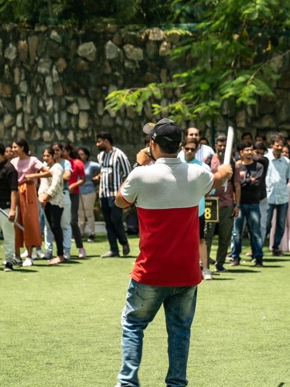 An instructor explains the rules of a game to a large group, getting them hyped for the challenges ahead.