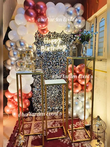 A romantic and glamorous setup featuring a floral-patterned sequin wall. The balloon arch in rose gold, silver, and white creates a soft and beautiful frame.