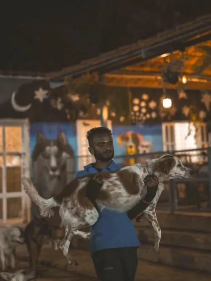 One of our dedicated crew members carries a dog through the busy park at night, ensuring everyone is safe and happy.
