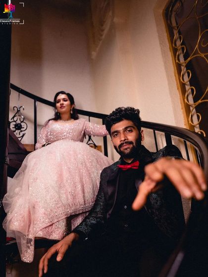 A stylish portrait of the couple on a spiral staircase. The unique angle and their elegant reception attire create a dramatic and fashionable photograph.