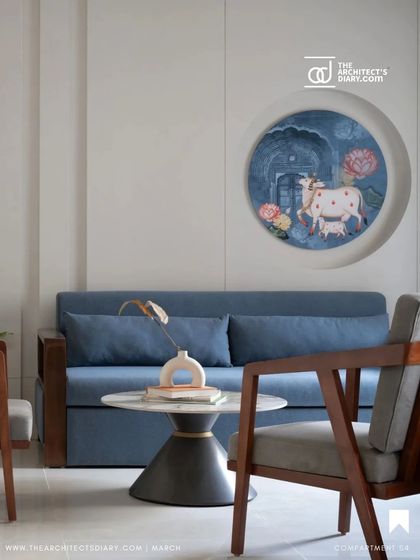 This quiet corner in the Oatmeal House features a custom-designed sofa in a deep blue, set against a wall with a circular niche showcasing a traditional Pichwai painting. The space is a perfect example of how we integrate art and modern furniture to create moments of beauty and calm.
