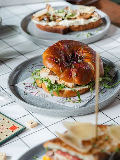 A breakfast spread for every taste, featuring our bagel sandwiches, toasts, and board games for a fun morning.