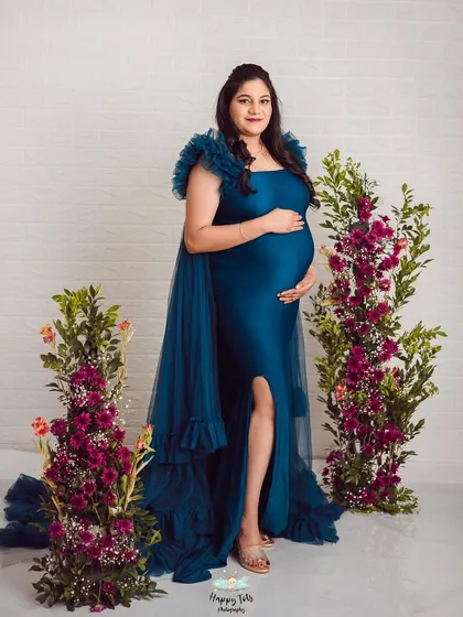 This pose shows off the beautiful fit of the gown and the flowing train. The mom-to-be looks absolutely radiant and confident.