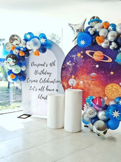 A cosmic celebration for a 9th birthday. This space-themed setup features a galaxy backdrop, planet-themed balloons, and a personalized sign, ready to take the birthday boy and his friends on a stellar adventure.