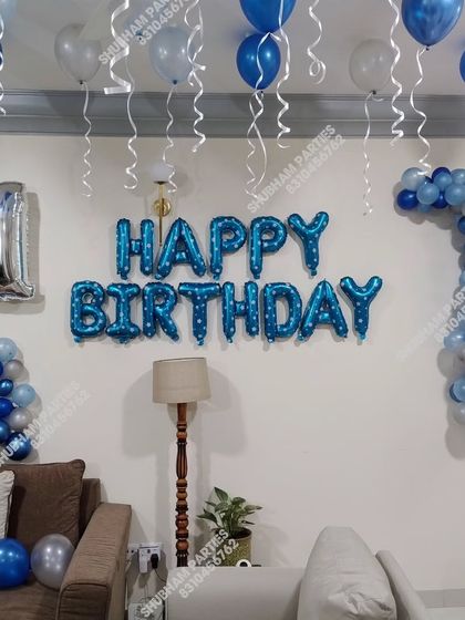 A blue and silver themed first birthday decoration in a living room.