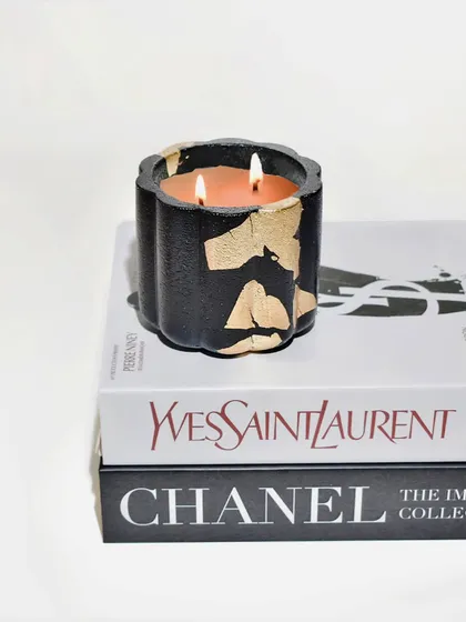 The black and gold Daisy Jar is a statement piece. It sits beautifully on a stack of fashion books, adding a touch of chic to your decor.