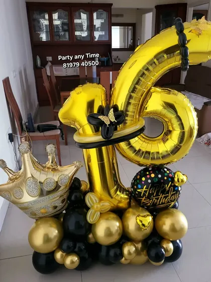 A 16th birthday number bouquet in black and gold with a crown.