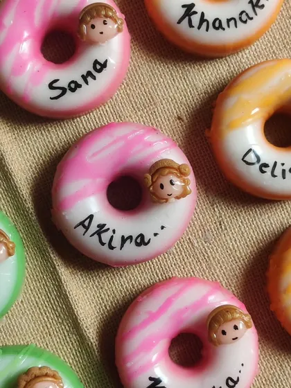 A close-up of the personalized donut soaps, showing the handwritten names like Sana, Akira, and Delisha.