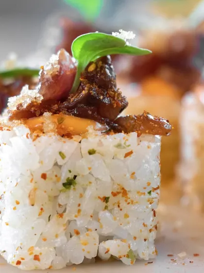 A close-up of our gourmet sushi, showcasing the intricate topping of sautéed mushrooms and a sprinkle of Japanese spices.