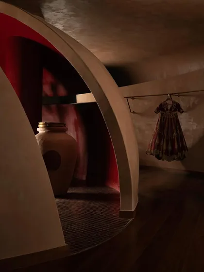 An arched opening reveals a space washed in deep red, a sacred inner sanctum for the most special pieces.