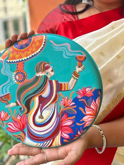 A close-up of one of the Pujo plates, depicting a woman performing the 'dhunuchi' dance.
