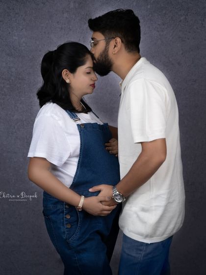 A tender kiss on the forehead. This simple gesture is full of love and captures the protective bond between the couple.