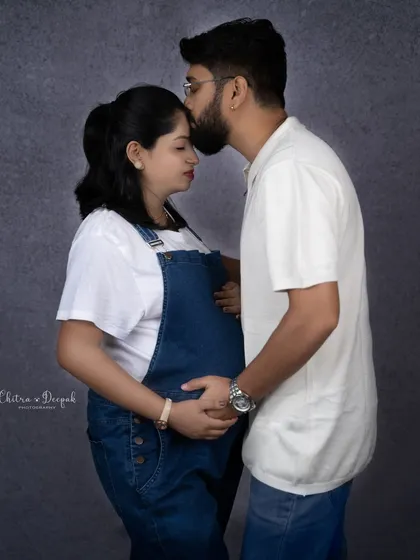 A tender kiss on the forehead. This simple gesture is full of love and captures the protective bond between the couple.