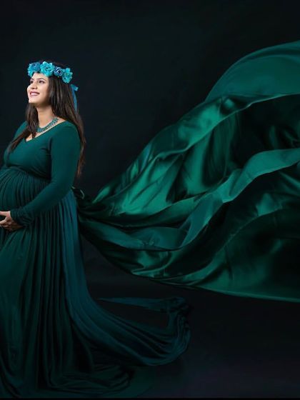 A dramatic fabric toss with a deep green gown against a black background. This creates a powerful and artistic image that emphasizes the flow and movement of the dress.