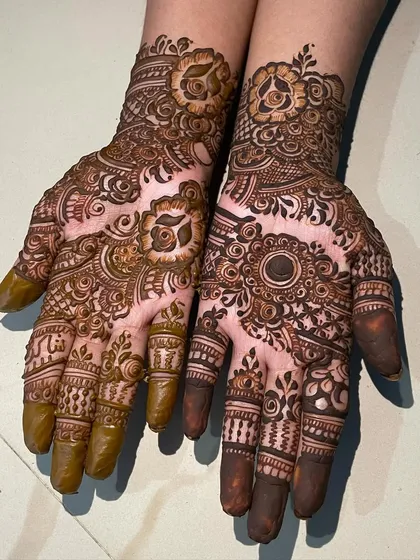 A beautiful example of asymmetrical designs, where each hand has a unique pattern that still complements the other. One hand features a floral theme, while the other has a mandala.
