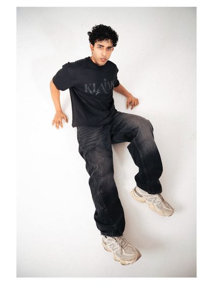 An artistic, high-angle shot that creates a floating effect. This unconventional composition is memorable and makes the streetwear outfit look dynamic and cool.