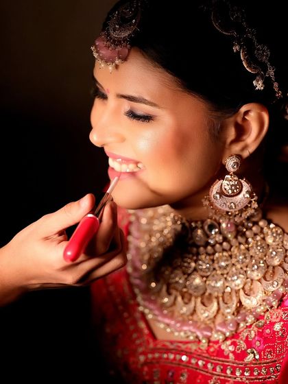 A close-up shot of the bride applying lipstick. This detail-oriented photo captures the final touches of the getting-ready process, adding to the story of the day.