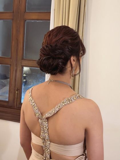 This low textured updo is perfect for a reception or engagement gown. The interwoven sections create beautiful dimension that looks stunning from every angle.