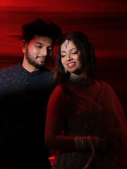 A dramatic and romantic shot of the couple. The soft glam Sangeet makeup I created for them looked stunning under the bold red lighting.