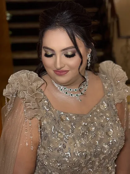 A full view of the eye makeup for this stunning reception look. The combination of gold glitter and a sharp wing is a classic choice for evening events.