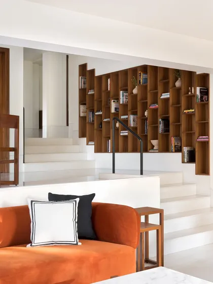 The recessed bookcase serves as the focal point of this home, accessible from all three levels. I designed it to encourage reading and interaction, with wide steps nearby offering a place to sit and browse.