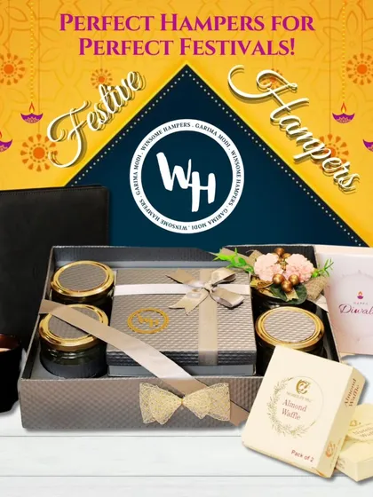 A sophisticated Diwali gift set perfect for corporate or personal gifting. This hamper includes a leather-bound journal, jars of gourmet snacks, almond waffles, and a scented candle, all presented in a sleek grey and silver box.