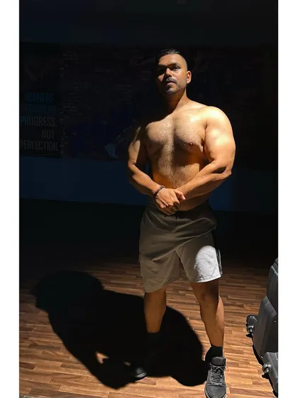 A physique shot in the gym. The dramatic lighting highlights the muscle and conditioning that I help my clients build.