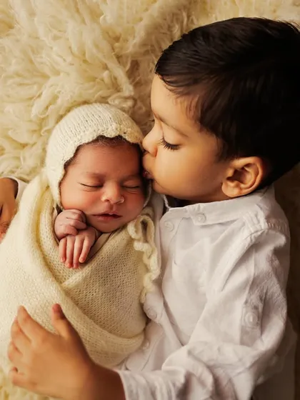 He's a big brother now. This overhead shot of a proud brother holding his new sibling is simply heart-melting.