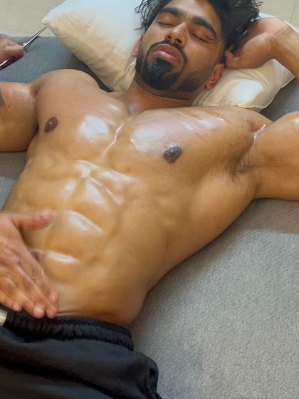 A close-up of IFBB Pro Amit Agre relaxing during a Graston therapy session on his abdominals, a crucial part of his prep for Olympia.