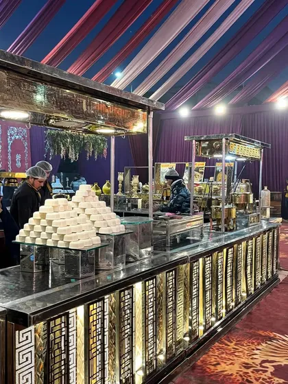 This dessert station features pyramids of traditional Indian sweets like sandesh, set up on a modern, illuminated counter. It's a perfect blend of classic taste and contemporary presentation.