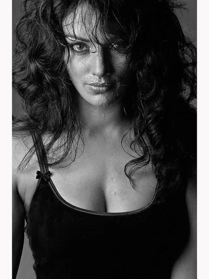 An intense close-up portrait with a wet look, captured in black and white. This style creates a raw and emotive mood, stripping back distractions to focus purely on the subject's expression.