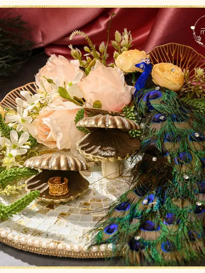 For engagements, I design platters that are as memorable as the moment itself. This piece, from my Ibtidaa collection, features a majestic peacock motif, delicate florals, and shell-shaped ring holders on a mosaic tray, creating a truly regal start to a new journey.