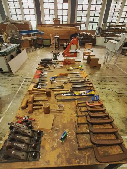 A complete set of hand tools laid out on a workbench. We ensure our students have access to everything they need to learn and master conventional woodworking skills.