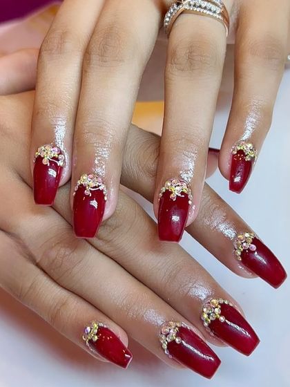 A bold and beautiful red coffin set with intricate rhinestone clusters at the cuticle.