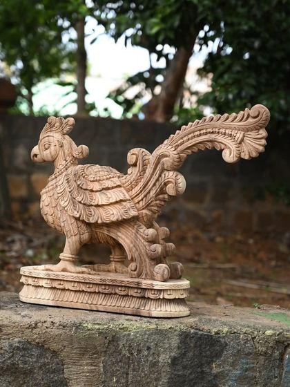 Another angle of the natural finish wooden parrot, highlighting the intricate carving of its feathers.