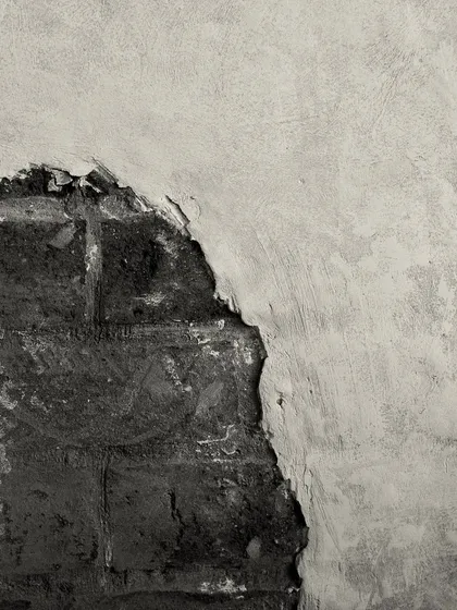 A close-up of the intentionally distressed wall finish, revealing the brickwork beneath. This technique adds a sense of history and character to the space.