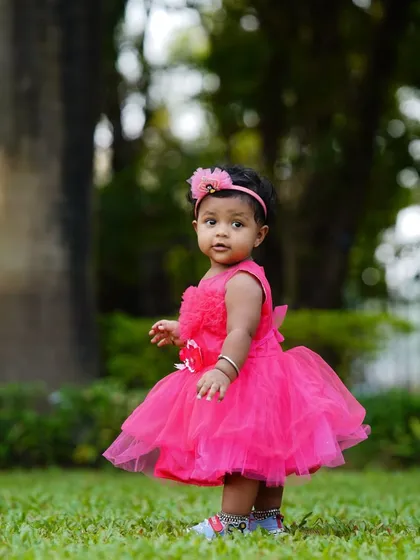 A lovely candid shot of a toddler in a pink dress, captured mid-step during her outdoor photoshoot. I focus on capturing these natural, unposed moments.
