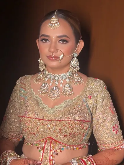 A front view of a bride with a beautiful floral bun. The hairstyle is pulled back neatly to highlight her features and stunning bridal jewellery.