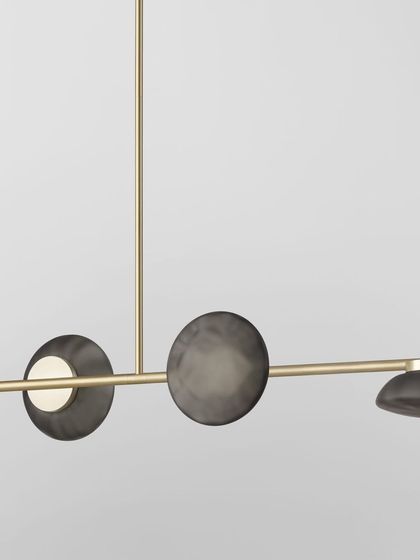A linear Ceto configuration with a brass finish, its shades oriented in different directions to create a dynamic and playful composition.