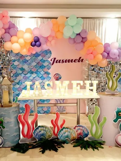 I built this underwater fantasy for Jasmeh's mermaid-themed party. The backdrop combines a shimmer panel with a pastel balloon garland, complemented by custom-made props like a mermaid tail, seahorses, coral, and seashells to create a complete ocean scene.