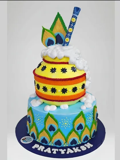 As a whipped cream specialist, I love creating vibrant, detailed designs like this Krishna-themed cake. It features a hand-piped 'matki' and peacock feathers, demonstrating the sharp details and rich colors I can achieve without using fondant.