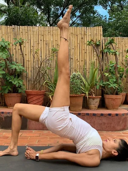 This is Eka Pada Setu Bandhasana, or one-legged bridge pose. It's a gentle inversion that strengthens the back, opens the chest, and calms the nervous system. This pose is wonderful for improving circulation and can be particularly beneficial for relieving menstrual discomfort.