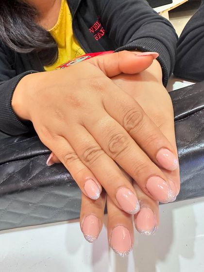 Simple yet stunning. These short, natural-looking nails are given a touch of class with a subtle silver glitter French tip.