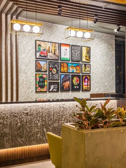 A focused shot of the cash counter, highlighting the material contrast between the monolithic stone-look base and the polished wood fluted panel behind it. This detail exemplifies our approach to creating visual interest through texture and material selection.