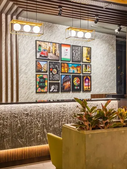 A focused shot of the cash counter, highlighting the material contrast between the monolithic stone-look base and the polished wood fluted panel behind it. This detail exemplifies our approach to creating visual interest through texture and material selection.