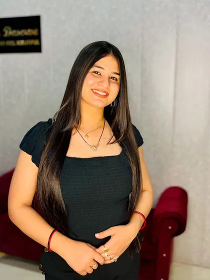 A smiling client, happy with her hair transformation. The subtle color and sleek styling give her a polished and confident look.