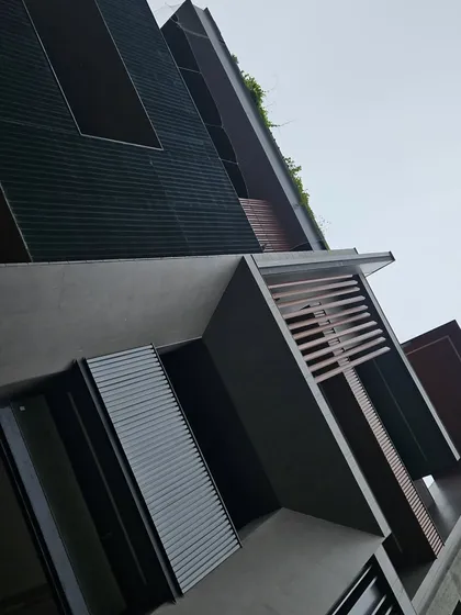 A close-up of a facade featuring brutalist architectural elements. I used a combination of earthy textures, including exposed concrete, treated wood, and aluminum louvers, to create a visually rich and durable exterior.